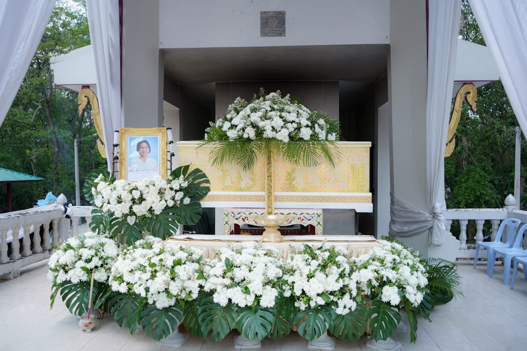 Personalised funeral setup with white flowers and memorial photos